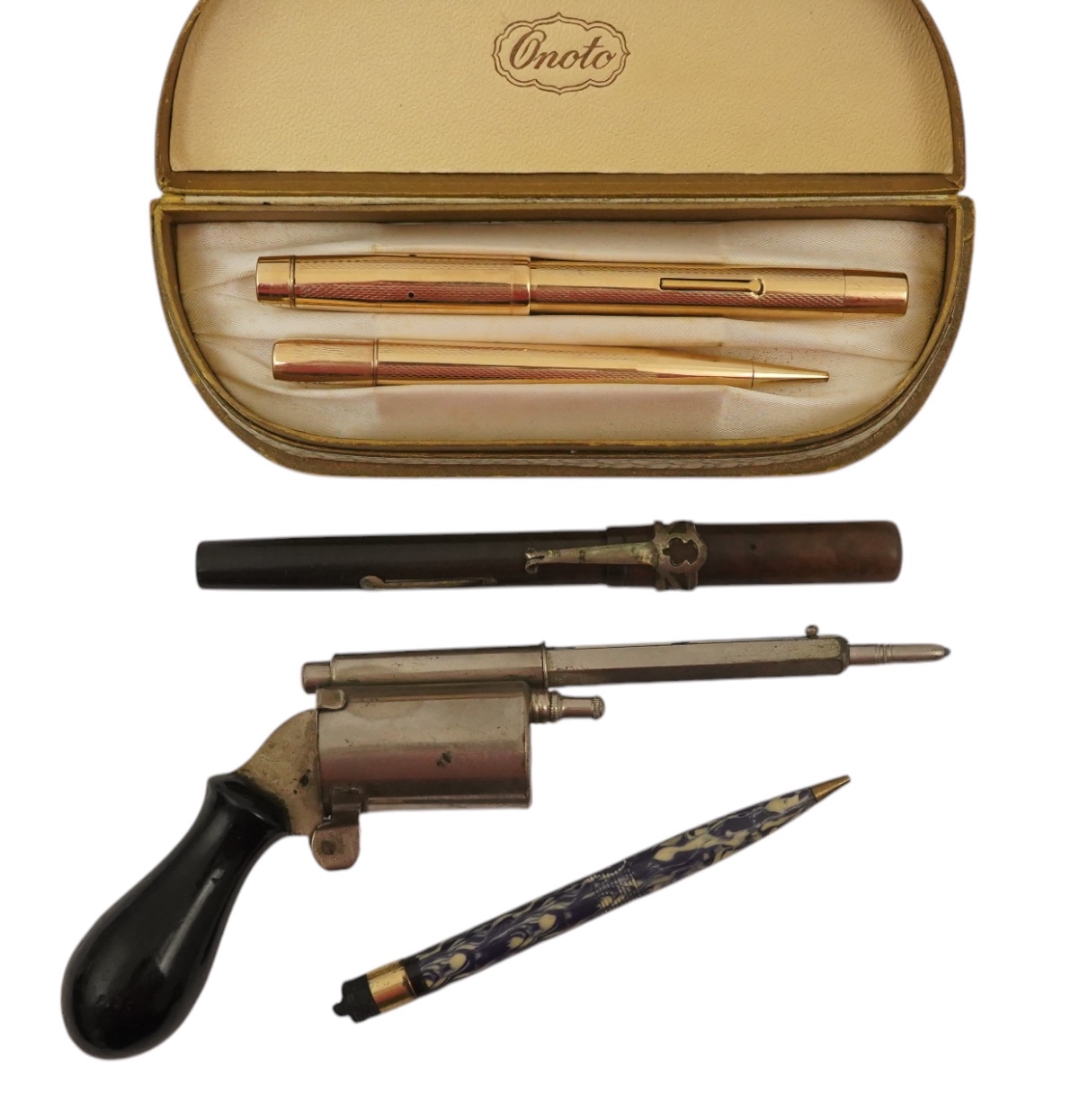 A novelty gun propelling pencil, a gold plated De La Rue Onoto fountain pen and matching pencil, in original box and two other items